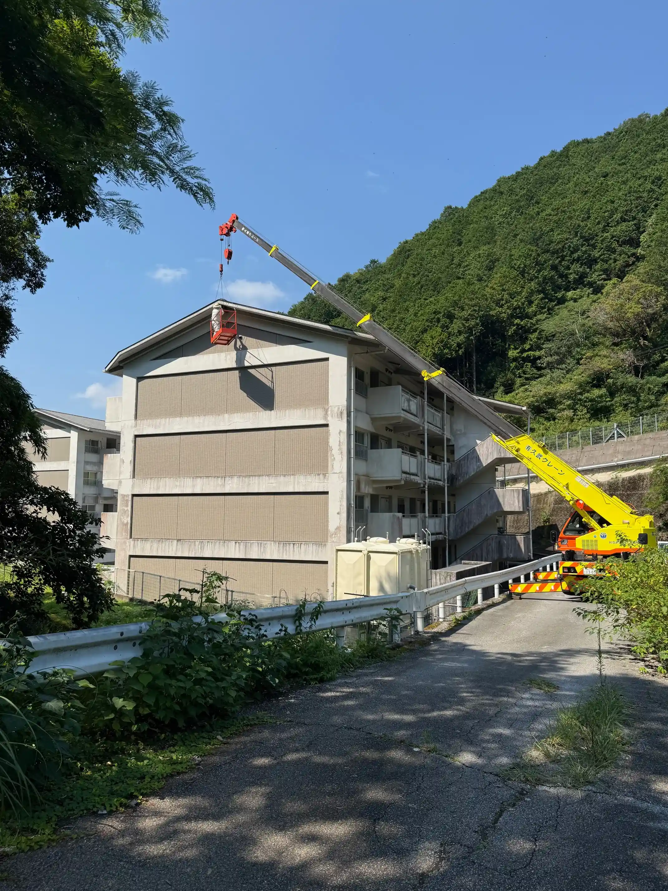 4階建てマンション屋根付近の蜂の巣を駆除｜クレーンを使用した高所作業で安全に対応